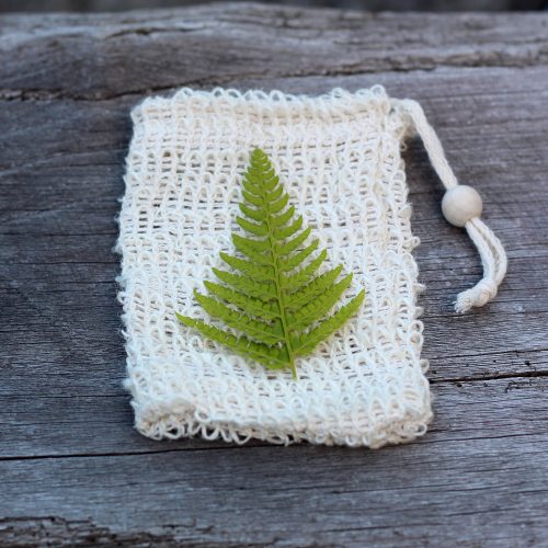 Hoja verde sobre bolsa de fibra natural.