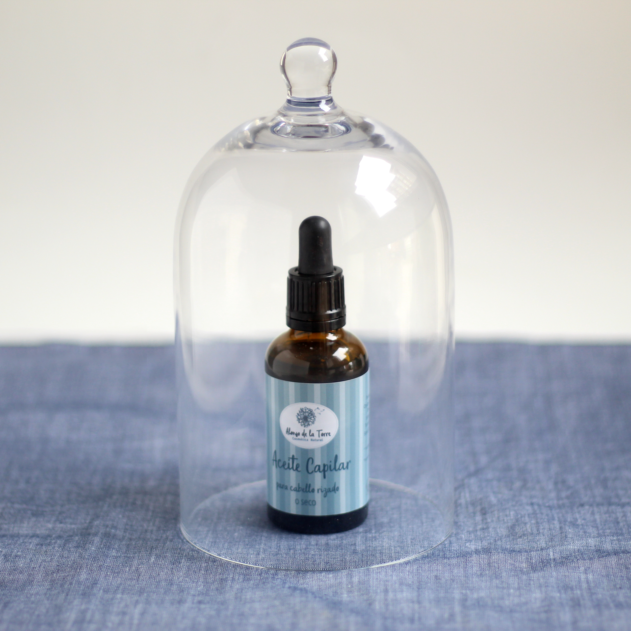 Botella de aceite capilar bajo campana de vidrio.
